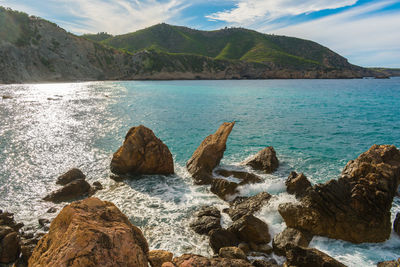 Scenic view of sea and mountains against sky