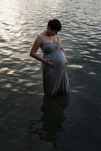 Rear view of woman standing in lake