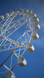 Low angle view of ferris wheel against blue sky