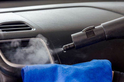 Close-up of equipment spraying water on air condition in car