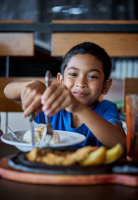 Portrait of boy with ice cream in restaurant