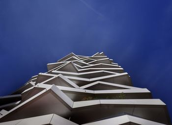 Low angle view of modern building against blue sky