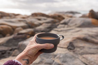 Close-up of hand holding tea cup