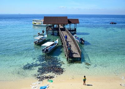 Boats moored by jetty in sea at kodingareng keke island against sky