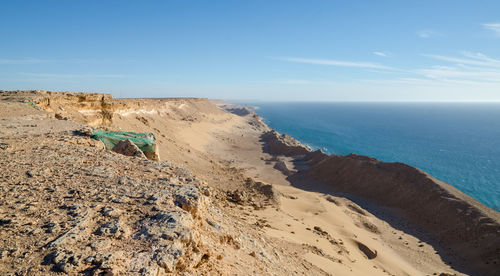 Scenic view of atlantic coast against blue sky with simple fisherman tent, western sahara, north africa