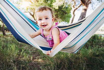 Portrait of happy girl sitting on hammock
