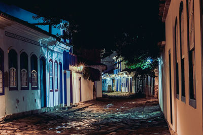 Street amidst buildings in city at night