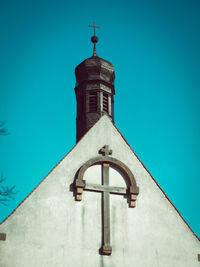 Low angle view of tower and building against clear blue sky