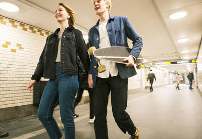 Happy young couple walking in illuminated underground walkway