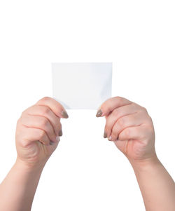 Midsection of person holding paper against white background