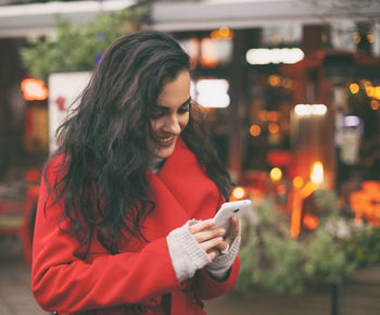 Young woman using mobile phone at night