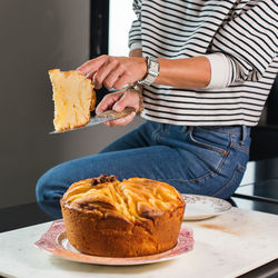 Young beautiful woman cutting homemade apple pie at the modern kitchen