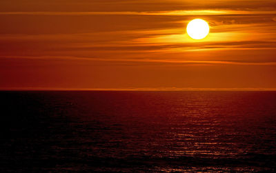 Scenic view of sea against orange sky