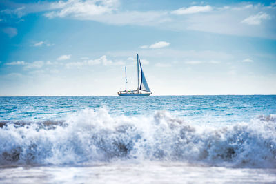 Sailboat sailing on sea against sky