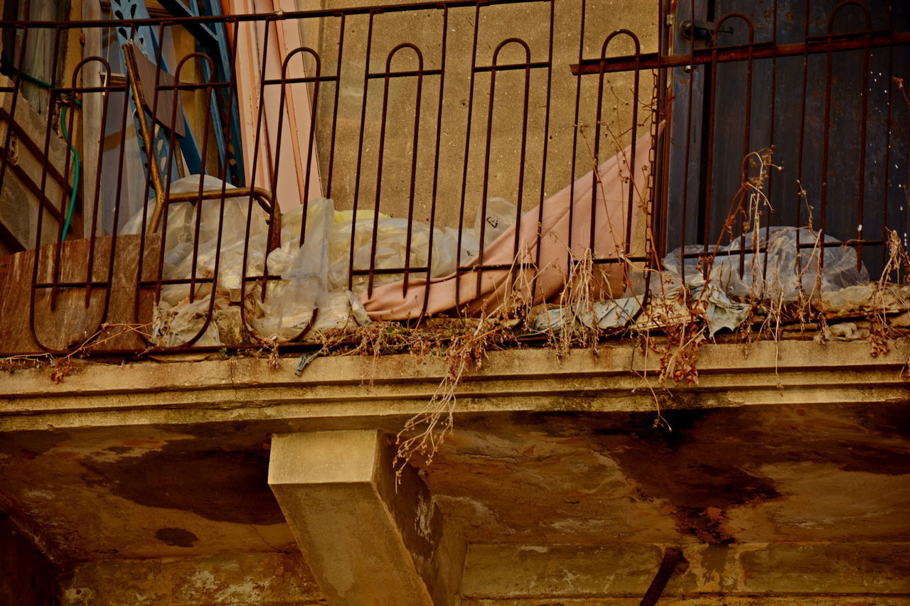 ABANDONED METAL GATE AGAINST BUILDING