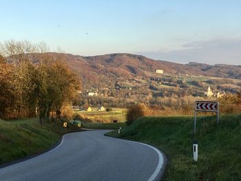 Road leading towards mountains against sky