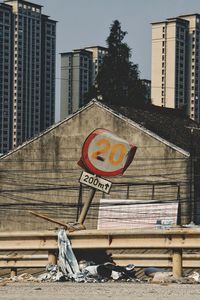 Information sign by buildings in city against sky