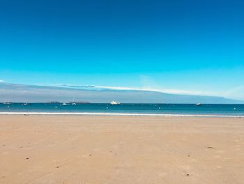 Scenic view of beach against blue sky