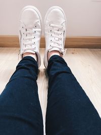 Low section of woman sitting on hardwood floor