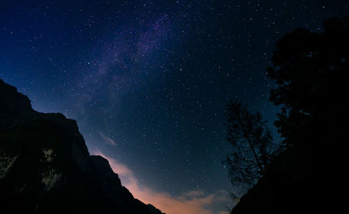 Low angle view of mountain against sky at night with milky way