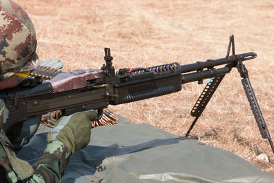 Soldier shooting from gun on field