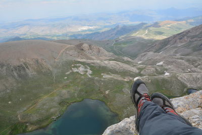 Low section of hiker on rock by mountains