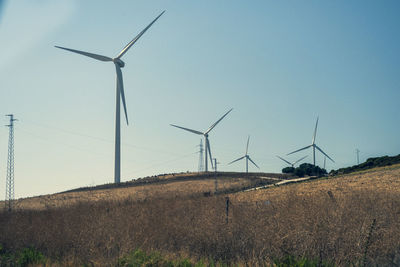 Windmill on field against clear sky