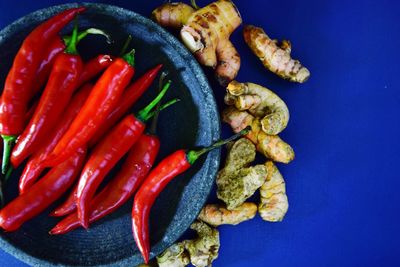 High angle view of chili peppers on blue container