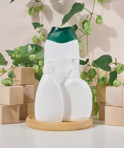 Empty white plastic bottle for gel, shampoo and other liquid cosmetics on a beige background