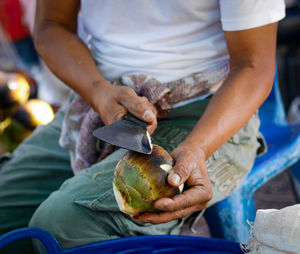 Midsection of man preparing food at market