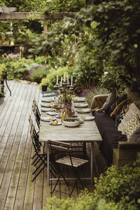 Dining table arranged by plants in back yard for party