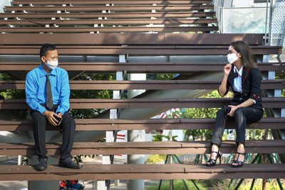 Young man sitting on railing