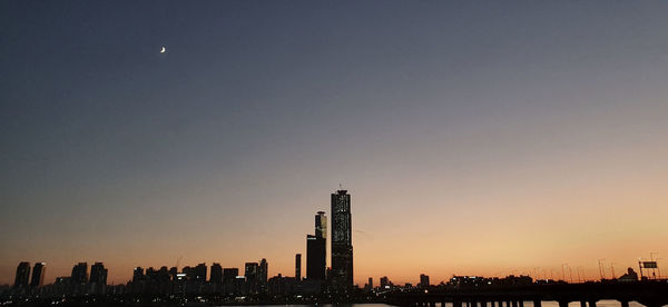 Silhouette buildings against sky at night