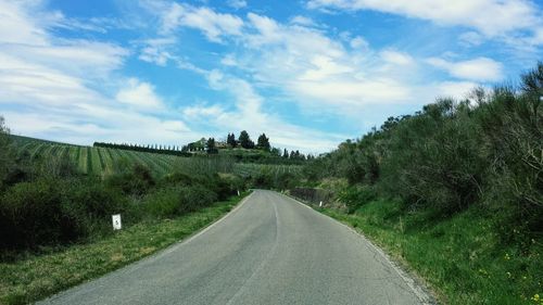 Road amidst trees against sky