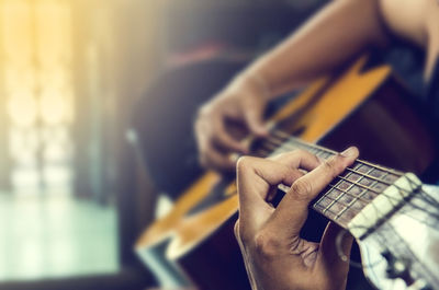 Cropped hands of man playing guitar