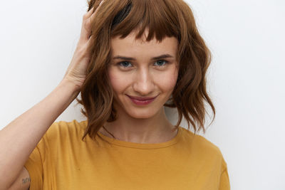 Portrait of young woman against white background