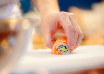 Cropped hand of person holding orange juice