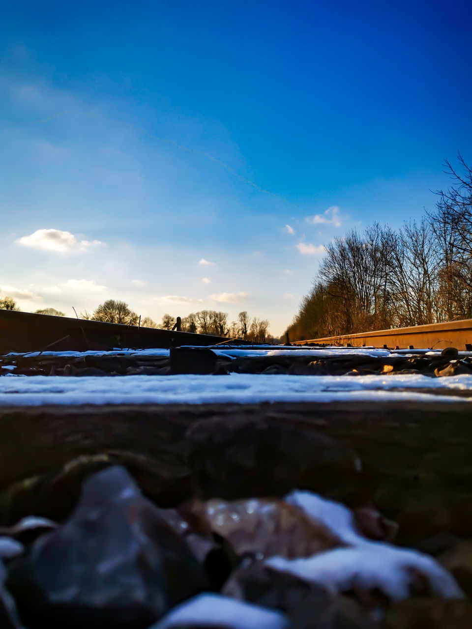 SURFACE LEVEL OF FROZEN LAKE AGAINST SKY DURING SUNSET