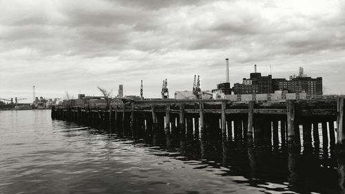 Pier over sea against cloudy sky