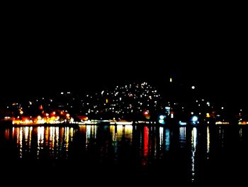 Illuminated city against clear sky at night