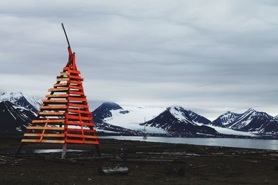 Built structure on snowcapped mountain against sky
