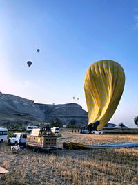 Hot air balloons flying over land against sky