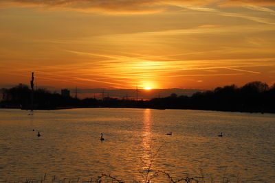 Scenic view of lake against orange sky