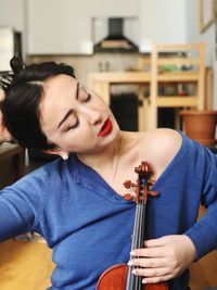 Young woman playing guitar at music concert