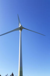 Low angle view of wind turbine against blue sky