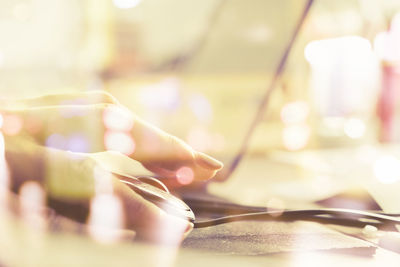 Close-up of human hand using mouse at desk