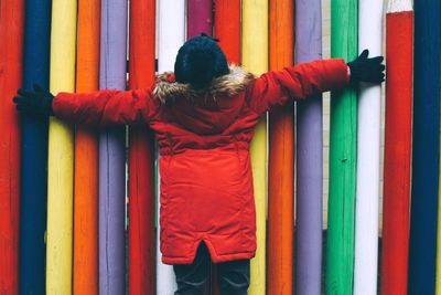 Rear view of man standing against multi colored wall