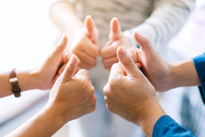 Close-up of friends showing thumbs up