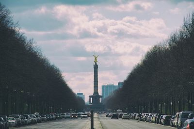 Road leading towards berlin victory column in city against sky