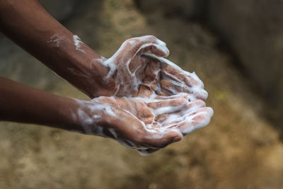 Close-up of person hand on wet shore